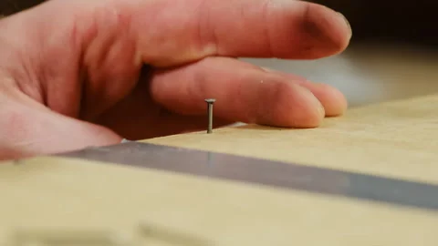 Man hands install small nail into wooden detail with hammer Video stock 304396537