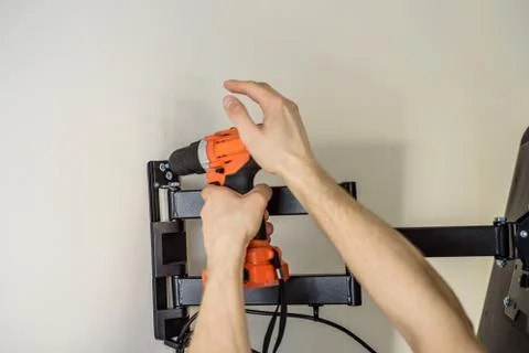 Man hands installing mount TV on the wall Stock Photos
