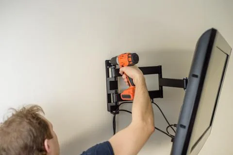 Man hands installing mount TV on the wall Stock Photos