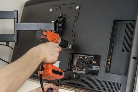 Man hands installing mount TV on the wall Stock Photos
