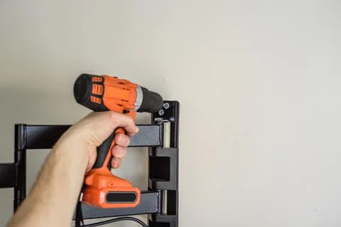 Man hands installing mount TV on the wall. Copyspace Stock Photos