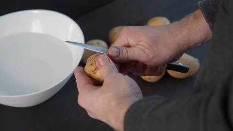 Man hands with a knife peel clean potatoes Stock Footage 132287904