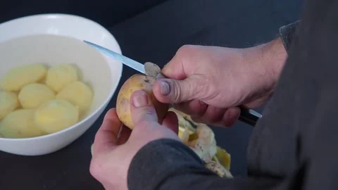 Man hands with a knife peel clean potatoes Stock Footage 132287914