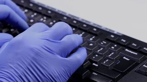 Man hands in latex gloves typing on computer keyboard Coronavirus prevention. Stock Footage 129824448