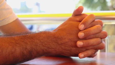 Man hands lying together with fixing fingers on the table and make sign of Stock Footage 140248458