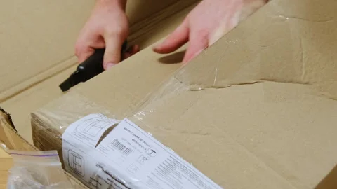 Man hands open cardboard box with labels cutting adhesive tape Stock Footage 304400731