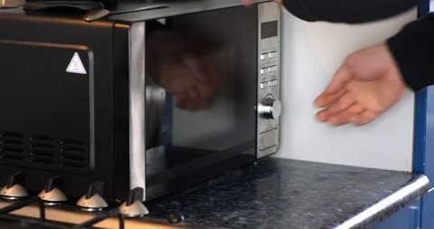 Man hands open microwave and take out plates of soup Stock Footage 104872372
