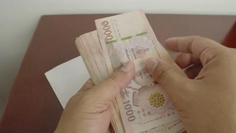 Man hands open white envelope with thousands Thai baht banknotes Stock Footage 236369741