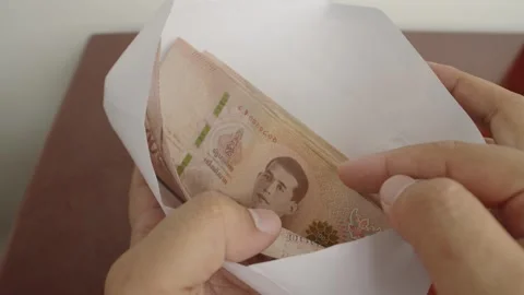 Man hands open white envelope with thousands Thai baht banknotes money. Stock Footage 243890778