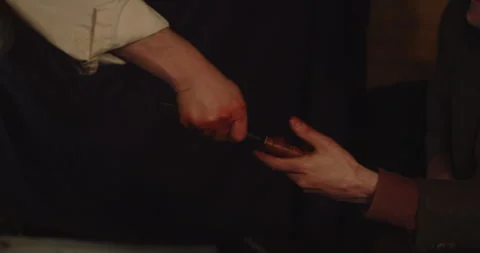 A man hands over a World War 2 combat knife to someone else in hideout Видео 327279122