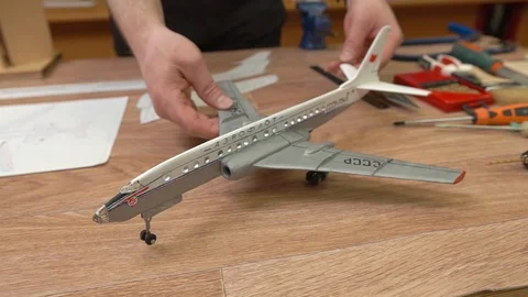 Man hands perform outdated wooden Ilyushin jetliner model 스톡 동영상 126895486