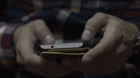 The man in the hands of the phone. The guy sitting on a chair holding a Stock Footage 67669286