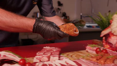 Man hands placing a roll of home-made sausage ring on a wooden cutting board. Stock Footage 295268308