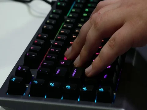 Man hands playing on a computer keyboard. Keyboard with green-blue light. Stock Footage 81374641