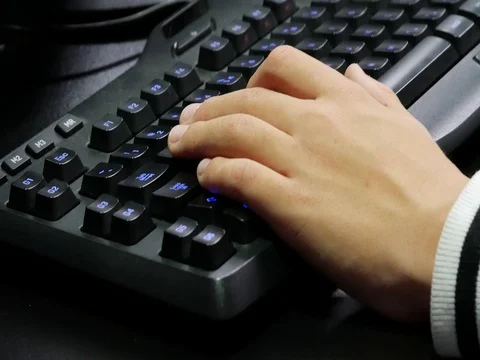 Man hands playing on a gaming computer keyboard. Keyboard with green-blue light. Stock Footage 81374658