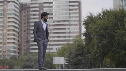 Man with hands in pockets goes down to girl against city Stock Footage 103935014