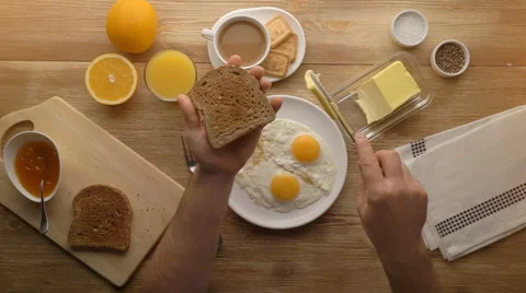 Man hands preparing breakfast toast with butter, top view Stock Footage 67532226