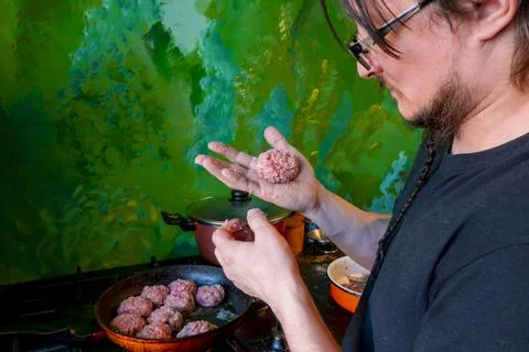 Man hands preparing meatballs with raw mincemeat. Lifestyle close up composit Stock Photos
