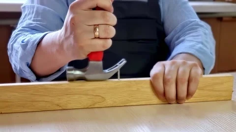Man hands pulling out a nail from wooden bar. Stock Footage 231145841