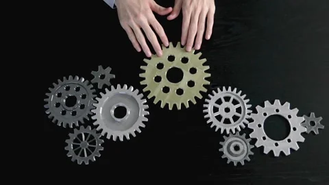 Man hands putting a cogwheel into a common mechanism. Stock Footage 260233329