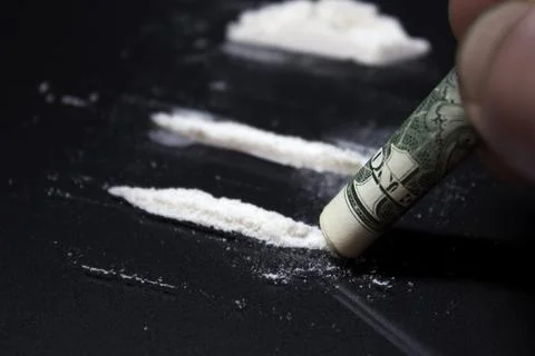 Man hands rolls banknote for using cocaine powder lines Stock Photos