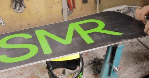 Man Hands With Scraper Scrape The Wax Off The Snowboard. High Angle Stock Footage 125858803