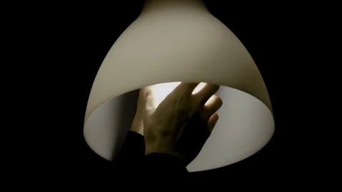 Man hands screw the bulb into the lamp. Isolated on the black background. Stock Footage 121623965
