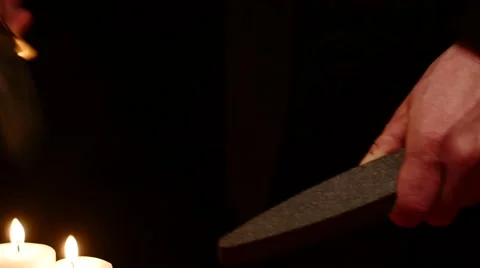 Man hands sharpening battle knife on black background with candles  4k Stock Footage 45910077