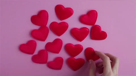 Man hands with small red heart shapes on pink background happy valentines day Stock Footage 121668747
