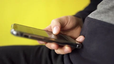 Man hands with smart phone close up on yellow background. Easy pay online Stock Footage 152834969