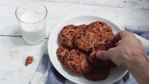 Man hands take chocolate cookie and glass of milk Stock Footage 132331438
