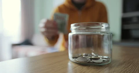 Man hands take out several banknotes of cash from glass jar. The cash in the Stock Footage 240223842