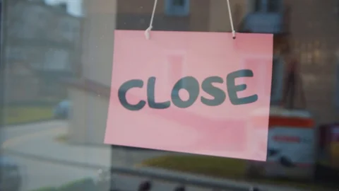 Man hands turning over a "close" sign in his cafe door. Close up shot. Stock Footage 91040227