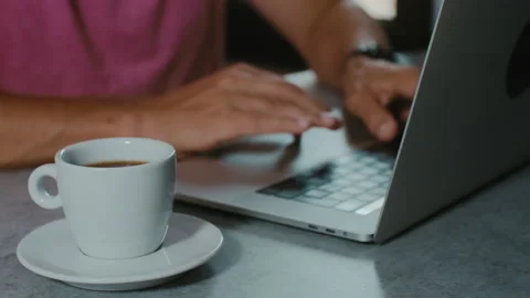 Man hands typing on keyboard of laptop in cafe and drinking coffee 스톡 동영상 135164615