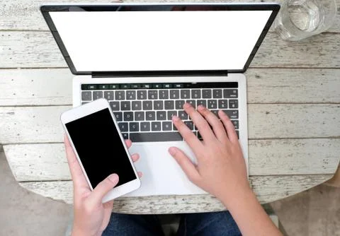 Man hands typing laptop computer and smart phone with blank screen for mock u Stock Photos