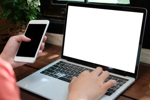Man hands typing laptop computer and smart phone with blank screen for mock u Stock Photos