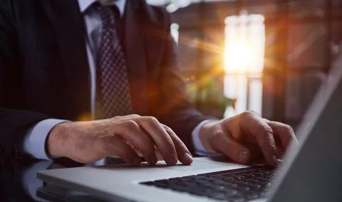 Man hands typing on laptop computer keyboard and surfing the internet on office Stock Photos