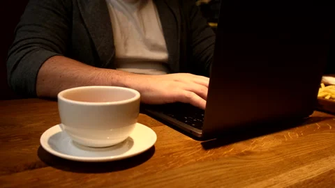 Man hands typing on laptop keyboard working in cafe drinking tea Video stock 169885805