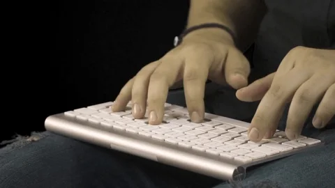 Man hands typing slow motion on a computer keyboard. Black background. Video stock 76394302