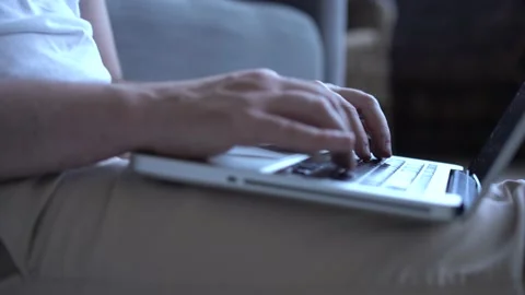 Man hands typing something on a laptop keyboard in the living room. Stock Footage 137971540