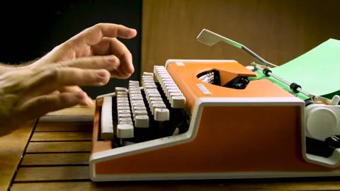 Man hands typing on a vintage typewriter. Old mechanical orange, white. Green Stock Footage 203787934