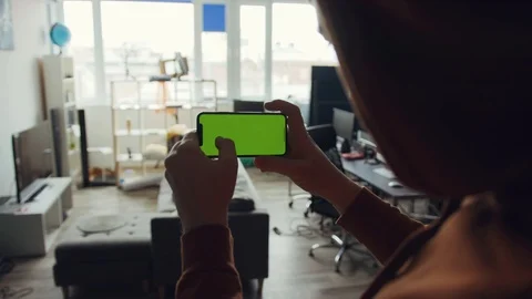 A man hands use phone with horizontal green screen stand in room at home Stock Footage 105203753