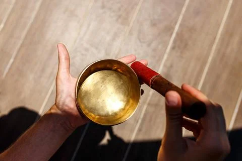 Man hands using singing bowl in sound healing therapy outdoors, closeup Stock Photos
