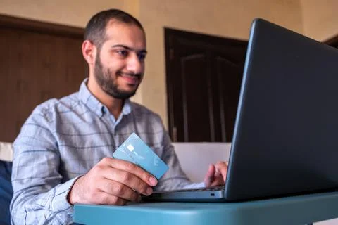Man hands using smartphone and laptop computer for online shopping at home Stock Photos