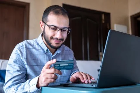 Man hands using smartphone and laptop computer for online shopping at home Stock Photos