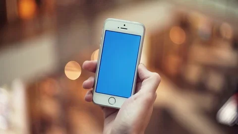 Man hands using smartphone with blue screen in shopping center Stock Footage 82990075
