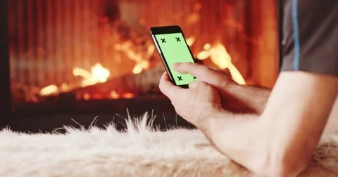 Man Hands Using SmartPhone with Green Screen by Fireplace. 4K SLOW MOTION 스톡 동영상 69259675