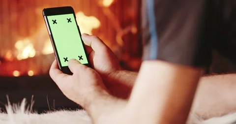 Man Hands Using SmartPhone with Green Screen by Fireplace. 4K SLOW MOTION Video stock 69260011