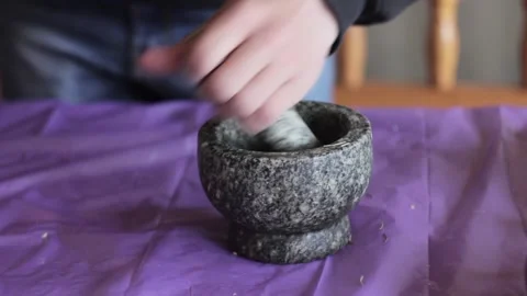 Man hands using stone mortar and pestle to grind herbs Stock Footage 117515166