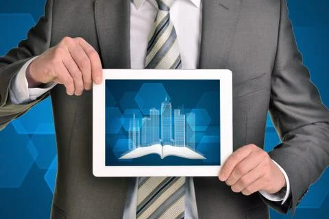 Man hands using tablet pc. Image of wire-frame buildings and open book on screen Illustrazione stock